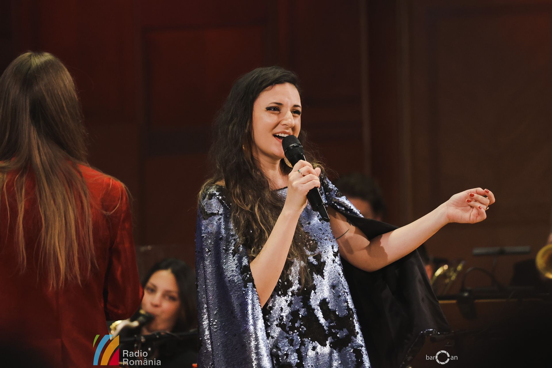 Mara Halunga singing in a sequin dress